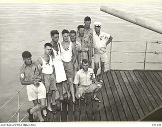 MILNE BAY, PAPUA, 1944-03-04. NAVAL PERSONNEL OF A GUN CREW ABOARD THE H.T. TAROONA ON ARRIVAL AT MILNE BAY DURING DISCHARGE OF AUSTRALIAN TROOPS FROM TOWNSVILLE, QUEENSLAND. IDENTIFIED PERSONNEL ..