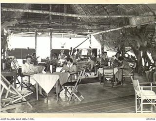 SEVENTEEN MILE, PORT MORESBY, PAPUA, NEW GUINEA, 1944-03-01. THE SISTERS' MESS AT THE 2/9TH GENERAL HOSPITAL HAS ALL RECREATIONAL FACILITIES. NURSES ARE PICTURED BEING ENTERTAINED IN THE MESS BY ..