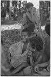 Children, child in foreground wears earrings and shell bead necklace