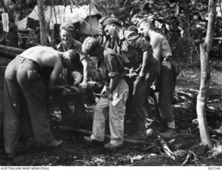 SCARLET BEACH AREA, NEW GUINEA. 1943-12-21. MEMBERS OF THE 1ST AUSTRALIAN TANK BATTALION GROUP WORKSHOP, AUSTRALIAN ELECTRICAL AND MECHANICAL ENGINEERS, REPLACING A REPAIRED UNIT IN A MATILDA TANK ..