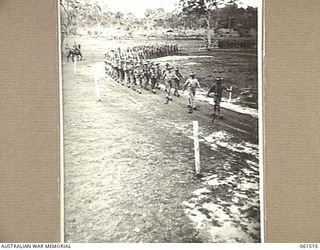 POM POM VALLEY, NEW GUINEA. 1943-11-30. 2/12TH AUSTRALIAN INFANTRY BATTALION, MARCHING PAST IN "COLUMN OF ROUTE". IDENTIFIED PERSONNEL ARE: WARRANT OFFICER I J. D. FRASER (1); TX2019 CAPTAIN U. J. ..