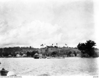 MANUS VILLAGE AND LANDING PIER, WITH THE DISTRICT OFFICER'S HOUSE ON THE HILL AT THE REAR. THE PHOTOGRAPH WAS TAKEN IN 1921, WHEN THE H.M.A.S. "BRISBANE", USING A GERMAN CHART, VISITED MANUS. ..