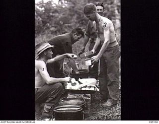 BUKAUA, NEW GUINEA. 1943-10-18. MESS PARADE IN THE OUTDOORS FOR THE TROOPS OF THE 29/46TH AUSTRALIAN INFANTRY BATTALION AT THE MISSION CHURCH. SHOWN: VX144429 PRIVATE (PTE) A. DUNCAN (1); VX118778 ..