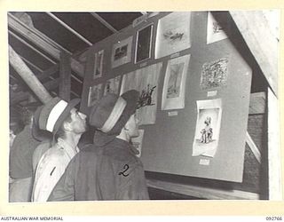JACQUINOT BAY, NEW BRITAIN. 1945-06-05. SERGEANT J. QUINLIVAN (1) AND PRIVATE DIXON (2), LOOKING AT THE BEGINNERS ART CLASS EXHIBITS DURING THE ARTS AND CRAFTS EXHIBITION SPONSORED BY ARMY ..