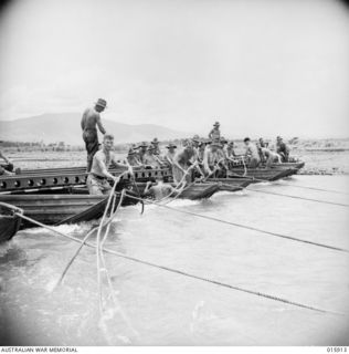 1943-10-02. NEW GUINEA. MARKHAM VALLEY. AUSTRALIAN ENGINEERS BRIDGE A TRIBUTARY OF THE MARKHAM RIVER, WHICH FLOWS AT SIX KNOTS AN HOUR. (NEGATIVE BY MILITARY HISTORY NEGATIVES)