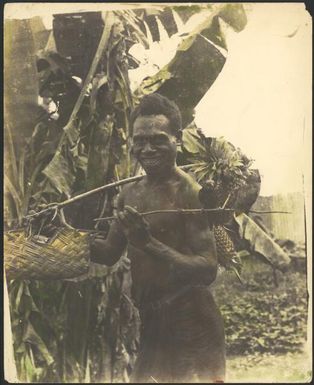 Smiling man with pineapples and parrots, Rabaul, New Guinea, ca. 1929 / Sarah Chinnery