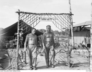 AITAPE, NORTH EAST NEW GUINEA. C. 1944-08. 74264 CORPORAL (CPL) J. HANNAH, AUBURN, NSW AND 76842 CPL W. STAKLEY, GYMPIE, QLD, MEDICAL ORDERLIES OF NO. 100 (BEAUFORT) SQUADRON RAAF, WALKING OUT OF ..