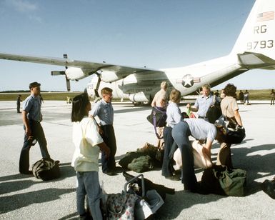 U.S. Navy personnel collect their belongings after arriving at Andersen Air Force Base on a Fleet Logistics Support Squadron 50 (VRC-50) C-130 Hercules aircraft. The sailors are being transferred to Guam from Naval Station, Subic Bay as that base prepares for closing