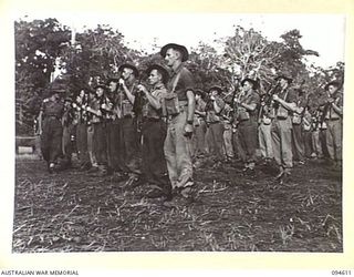 LAMARIEN, HENRY REID BAY, NEW BRITAIN, 1945-07-28. LIEUTENANT H.J. MORGAN, TROOP LEADER, A TROOP, 2/2 COMMANDO SQUADRON (1), INSPECTING THE WEAPONS OF HIS MEN DURING A PARADE