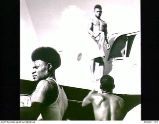 THE SOLOMON ISLANDS, 1945. BOUGAINVILLE ISLAND NATIVES LOADING A RAAF BRISTOL BEAUFORT AIRCRAFT WITH PAMPHLETS TO DROPPED TO THE JAPANESE FORCES. (RNZAF OFFICIAL PHOTOGRAPH.)