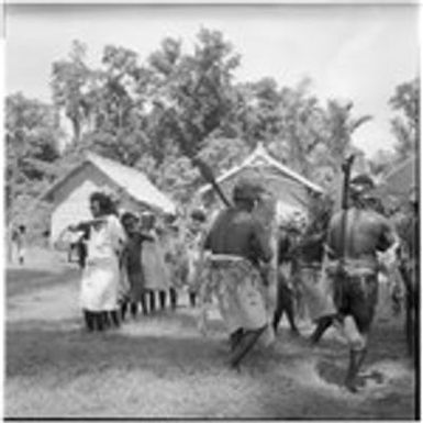 Men playing kiu, and women dancing