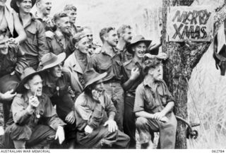 Kuba Lake, Ramu Valley, New Guinea. 1943-12-25. Members of the 2/14th Infantry Battalion, 7th Division, cheering competitors during the Christmas carnival and regatta on the lake