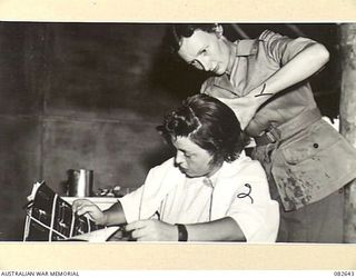 LAE AREA, NEW GUINEA. 1944-11-06. PRIVATE J. LEONARD (2), READING 'LIFE', WHILE HER HAIR IS SET BY PTE E. ANDREWS, AUSTRALIAN ARMY MEDICAL WOMEN'S SERVICE (1), A HAIRDRESSER WORKING IN HER CIVILIAN ..