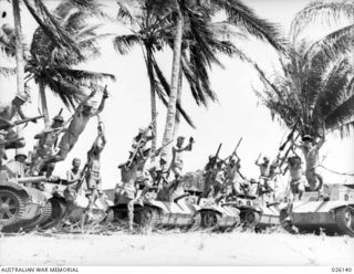 NEW GUINEA, 1942-08. CARRIER CREWS OF THE 39TH INFANTRY BATTALION, AUSTRALIAN MILITARY FORCES, IN HIGH SPIRITS, PHOTOGRAPHED IN A COCONUT GROVE IN NEW GUINEA