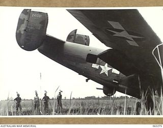 FAITA, NEW GUINEA. 1944-01-07. MEMBERS OF THE 2/2ND COMMANDO SQUADRON LOOKING OVER AN AMERICAN LIBERATOR (B-24) WHICH CRASHED ON THE AIRSTRIP RETURNING FROM A RAID ON WEWAK. THEY ARE: SERGEANT A. ..