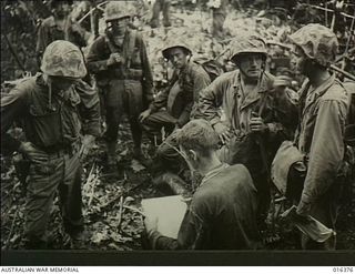 Cape Gloucester, New Britain. 1943-12-26. United States Marine Captain James L. Jordan of Shreve Port, Louisiana, USA, in conference with his troops after the beach-head had been established