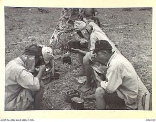 MUSCHU ISLAND, NEW GUINEA. 1945-09-11. A GROUP OF JAPANESE SOLDIERS HAVING THEIR MID-DAY MEAL. THEY SUPPLEMENTED THEIR OWN RATIONS WITH RICE BROUGHT OVER BY OUR BARGES. THE ISLAND IS NOW OCCUPIED ..