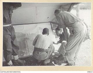 CAPE WOM, NEW GUINEA. 1945-10-19. THE WEWAK WAR CRIMES COMMISSION USING A MAP WHILE QUESTIONING LIEUTENANT MATSUBA OF THE JAPANESE ARMY. THE WEWAK WAR CRIMES COMMISSION IS TAKING EVIDENCE FOR ..