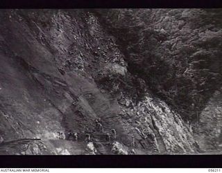 REINHOLD HIGHWAY, NEW GUINEA. 1943-08-22. ROCK FACE, THREE TO FOUR MILES ON THE BULLDOG SIDE OF JOHNSON'S GAP BEING WORKED BY SAPPERS OF THE 9TH AUSTRALIAN FIELD COMPANY, ROYAL AUSTRALIAN ENGINEERS