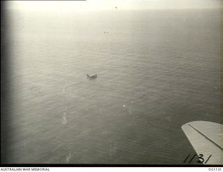 NEAR WEWAK. C. 1944-06. AERIAL VIEW OF A CATALINA FLYING BOAT RESCUING FROM THE SEA FLIGHT SERGEANT G. S. MOGG, MUDGEE, NSW, AN RAAF KITTYHAWK PILOT WHO HAD TO DITCH NEAR WEWAK. THIS PHOTOGRAPH WAS ..