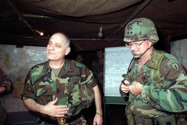 Army CHIEF of STAFF General (GEN) Carl E. Vuono, left, stands with Major General (MGEN) Charles P. Otstott, commander, 25th Infantry Division (Light), before a briefing in the tactical operations center during the general's visit to the training area