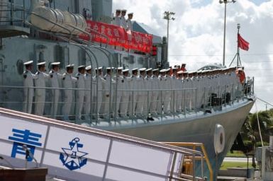 Chinese Peoples Liberation Army Navy Sailors from the Luhu (Type 052) Class Guided Missile Destroyer QINGDAO (DDG 113) dress left while manning the rails as they depart Naval Station Pearl Harbor, Hawaii, after a Goodwill Visit on Sept. 10, 2006. The visit provides an excellent opportunity to enhance cooperation between the two navies and underscores the United States commitment to supporting ongoing cooperative efforts in the Pacific Region. (U.S. Navy photo by Mass Communication SPECIALIST 1ST Class James E. Foehl) (Released)