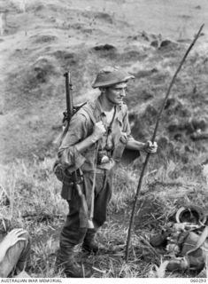 RAMU VALLEY AREA, NEW GUINEA. 1943-11-08. NX112073 LIEUTENANT G. ROBILLIARD OF NO. 18 PLATOON, 2/27TH AUSTRALIAN INFANTRY BATTALION PAUSES FOR A REST DURING A STEEP CLIMB