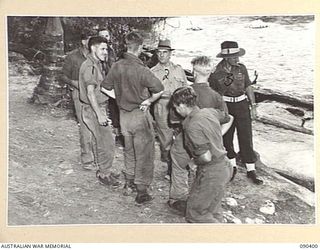 JACQUINOT BAY, NEW BRITAIN. 1945-04-08. SENATOR J.M. FRASER, ACTING MINISTER FOR THE ARMY (2), SPEAKING WITH INFANTRYMEN ON THEIR REST DAY. THEY ARE ON THE BANKS OF THE WUNUNG RIVER WHICH FLOWS ..