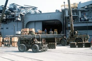 Crates of supplies are loaded aboard the amphibious assault ship USS GUAM (LPH 9) prior to the vessel's departure for the Middle East in support of Operation DESERT SHIELD