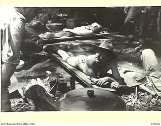 TSIMBA AREA, BOUGAINVILLE ISLAND. 1945-02-06. VX13 LIEUTENANT- GENERAL S.G. SAVIGE, CB, CBE, DSO, MC, ED, GENERAL OFFICER COMMANDING, 2ND AUSTRALIAN CORPS (1) CHATTING WITH SX39200 PRIVATE A.E. ..