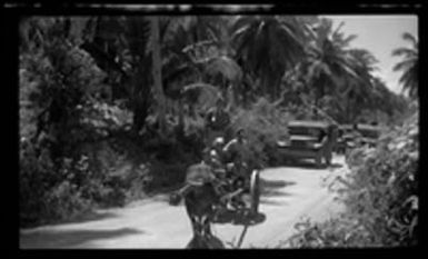 [Servicemen and children riding in ox cart]