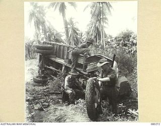 HANSA BAY, NEW GUINEA. 1944-07-10. TROOPS OF THE 5TH DIVISION CARRIER COMPANY, 5TH DIVISION SALVAGE GROUP, EXAMINE A WRECKED JAPANESE TRUCK DURING A PATROL TO REPORT USEFUL ENEMY EQUIPMENT IN THE ..