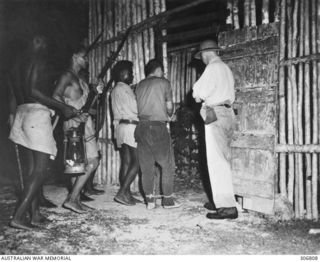 NEW GEORGIA, SOLOMON ISLANDS. 1943-03. A CAPTURED JAPANESE PILOT IS ESCORTED INTO THE STOCKADE AT KENNNEDY'S SEGI COASTWATCHERS STATION (ZGJ5). THE NATIVE SCOUTS ESCORTING THE CAPTURED ARE MEMBERS ..