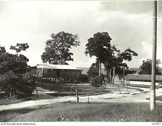 A SECTION OF THE MAIN ROADWAY WHICH PASSES THROUGH THE HEADQUARTERS AREA OF THE 23RD INFANTRY BRIGADE SHOWING THE INTELLIGENCE SECTION ON THE LEFT AND THE ORDERLY ROOM ON THE RIGHT