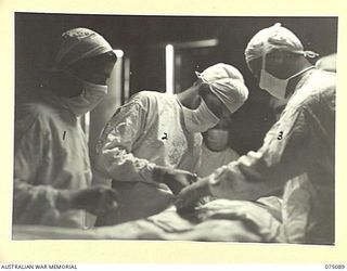 SOUTH ALEXISHAFEN, NEW GUINEA. 1944-08-08. DOCTORS PERFORMING A HERNIA OPERATION IN THE THEATRE OF THE 111TH CASUALTY CLEARING STATION