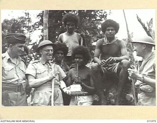 1942-10-08. AIR VICE MARSHAL G. JONES; MR DRAKEFORD (MINISTER FOR AIR), AND MR COLES, M.H.R., WITH A GROUP OF PAPUAN NATIVES. (NEGATIVE BY BOTTOMLEY)