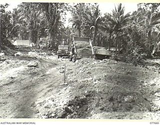 JACQUINOT BAY, NEW BRITAIN. 1944-12-11. TRUCK LOADS OF GRAVEL BEING TIPPED ON A NEW SECTION OF A ROAD BEING BUILT BY TROOPS OF THE 13TH FIELD COMPANY