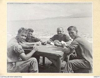 CAPE PUS, WEWAK AREA, NEW GUINEA. 1945-09-07. TROOPS OF 2/1 TANK ATTACK REGIMENT, PLAYING CARDS ON THE BEACH. IDENTIFIED PERSONNEL ARE:- GUNNER T.B. CROUCH (1); GUNNER B.F. ISON (2); GUNNER R.W. ..