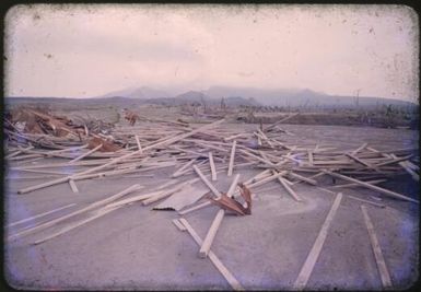 Ruins of the government store strewn on the parade ground at Higataru, Papua New Guinea, 1951 / Albert Speer