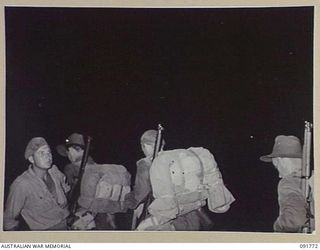 BOUGAINVILLE, 1945-05. MEMBERS OF 26 INFANTRY BATTALION (A.I.F.) AFTER A NIGHT LANDING ON TOROKORI ISLAND, EMBARKING ON BARGES. THE MEN LANDED AND PATROLLED THE ISLAND SEARCHING FOR A SUSPECTED ..