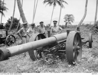 VUNAPOPE MISSION, RABAUL AREA, NEW BRITAIN. 1945-09-28. LIEUTENANT GENERAL J. NORTHCOTT, CHIEF OF GENERAL STAFF ACCOMPANIED BY HEADQUARTERS 11 DIVISION OFFICERS, INSPECTS A 150MM FIELD PIECE. THIS ..