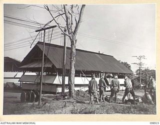 RABAUL, NEW BRITAIN. 1945-11-16. THE SIGNAL OFFICE, HEADQUARTERS 5 BASE SUB AREA UNDER CONSTRUCTION. JAPANESE WORKING PARTY IN THE FOREGROUND ARE PUTTING IN WIRING