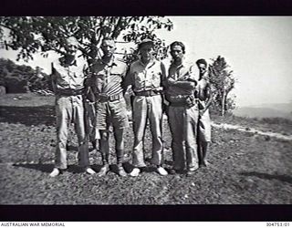 FINSCHHAFEN, PAPUA. GROUP PORTRAIT OF RADIO AIR GUNNER GRAHAM USAAC AND SERGEANT J. CHAMPAGNE USAAC WITH LOCAL NATIVE COASTWATCHERS. (NAVAL HISTORICAL COLLECTION)