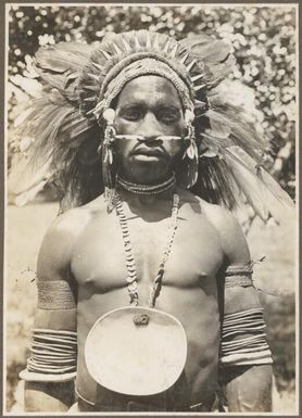Buna Bay District [man in head dress with a large shell around his neck] Frank Hurley
