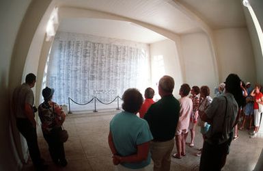 Visitors to the USS Arizona Memorial view a wall bearing the names of the sailors and Marines who died aboard the Arizona during the December 7, 1941, attack on Pearl Harbor
