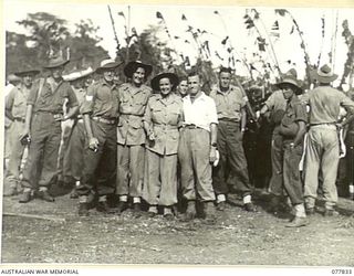 MALAHANG, LAE, NEW GUINEA. 1944-12-25. TWO MEMBERS OF THE AUSTRALIAN ARMY MEDICAL WOMEN'S SERVICE AND THEIR ESCORTS AMONG THE THRONG OF SERVICE PERSONNEL WHO ATTENDED THE NATIVE SING-SING AT THE ..
