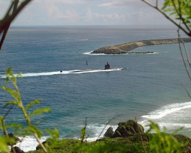 The LOS ANGELES class Attack Submarine USS TUCSON (SSN 770) glides past the mouth of Apra Harbor, Guam. The attack submarine has twelve launch missile tubes for Tomahawk cruise missiles to provide defense capabilities and retractable bow planes to give the vessel increased maneuverability. With it's stealth design, endurance, and mobility the TUCSON is able to operate in all ocean areas of the world. She is the 59th of her class and homeported out of Pearl Harbor, Hawaii