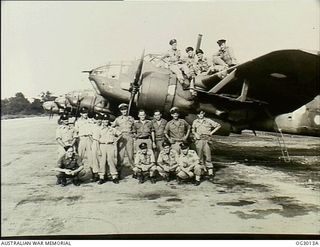 TADJI, NORTH EAST NEW GUINEA. 1945-06-27. GROUP PORTRAIT OF AIRCREW AND GROUND STAFF OF NO. 7 (BEAUFORT) SQUADRON RAAF. SOME ARE SITTING ON THE WING AND BESIDE A LINE OF AIRCRAFT ON THE AIRFIELD