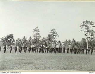 LAE, NEW GUINEA. 1944-09-09. A GUARD OF HONOUR OF THE LAE POLICE DETACHMENT OF THE ROYAL PAPUAN CONSTABULARY "PRESENT ARMS" TO THE GOC, NEW GUINEA FORCE, VX13, LIEUTENANT-GENERAL S.G. SAVIGE, CB, ..