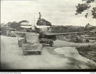 KIRIWINA, TROBRIAND ISLANDS, PAPUA. 1943-12-26. A KITTYHAWK FIGHTER AIRCRAFT, CODED SV-D, OF NO. 76 SQUADRON RAAF DAMAGED IN A LANDING BEING HAULED ON THE BACK OF A TRUCK INTO NO. 26 REPAIR AND ..